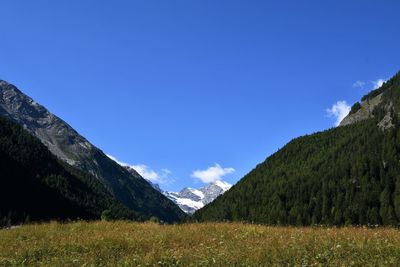 Scenic view of mountains against blue sky