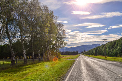 Road amidst trees against sky