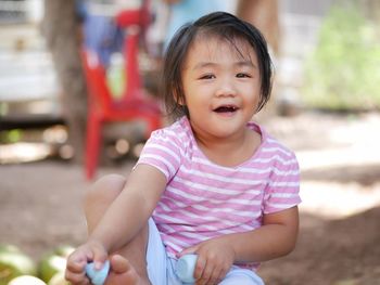 Portrait of cute girl sitting on land