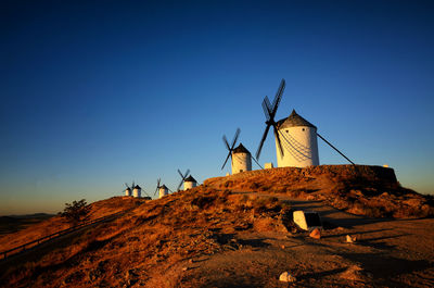 Low angle view of traditional windmill against clear blue sky