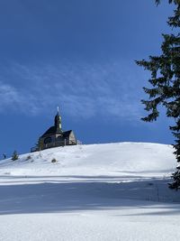 Church by building against sky during winter