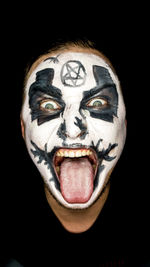 Close-up portrait of human face against black background