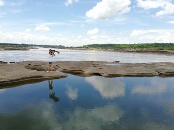 Woman standing on beach against sky