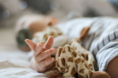 Low section of baby lying on bed