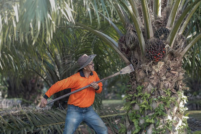 Man working on plants against trees