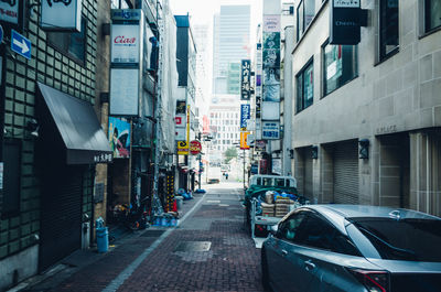 Cars on city street against sky