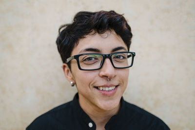 Close up view of a young transgender man looking at camera and smiling.