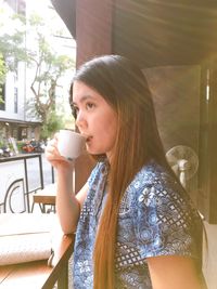 Beautiful young woman drinking glass