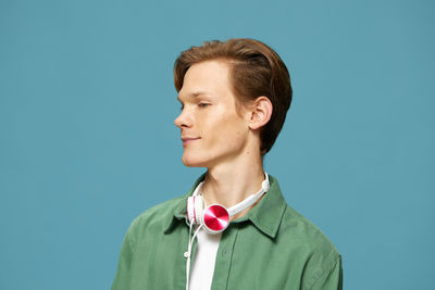 Portrait of young man against blue background