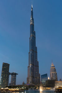 Illuminated buildings in city against clear sky