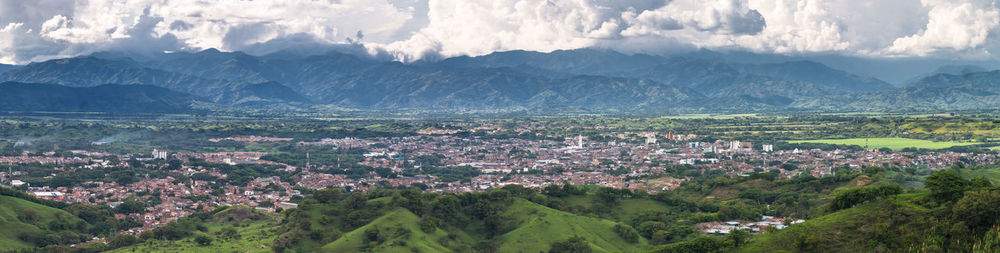 Aerial view of townscape and mountains against sky