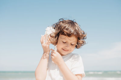 Portrait of boy on beach against sky