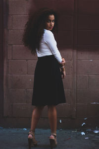 Woman standing in front of brick wall