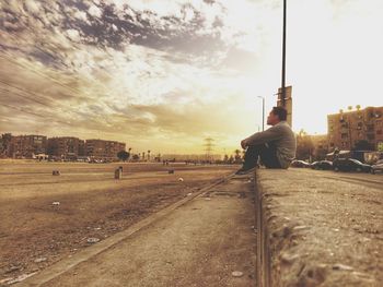 Man on road in city against sky