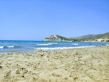 Scenic view of beach against clear blue sky