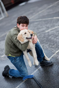 Full length of a boy hugging dog