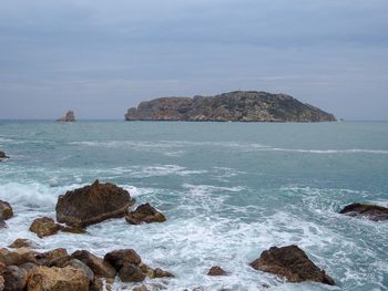 Scenic view of rocks in sea against sky