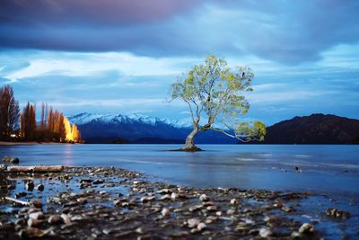 Scenic view of calm lake against cloudy sky