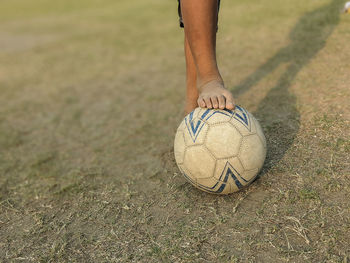 Low section of man playing soccer on field