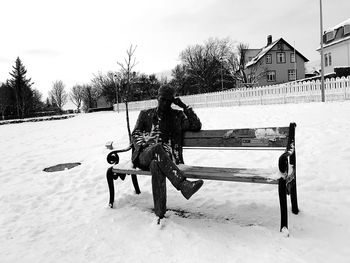 Boy in snow against sky during winter