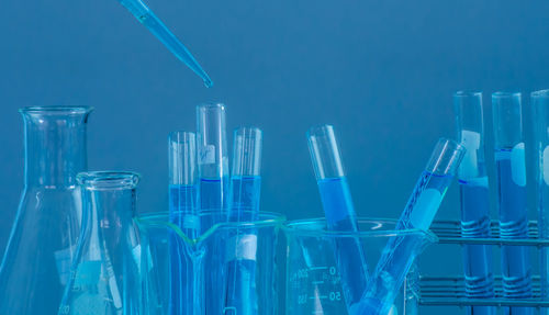 Close-up of laboratory glassware against blue background