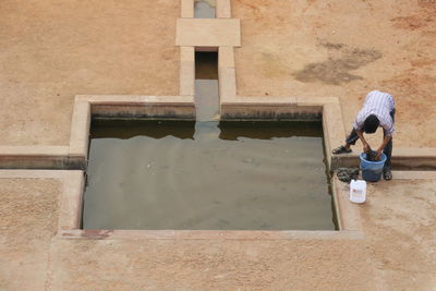 High angle view of boy sitting on wall