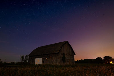 House on field against sky at night