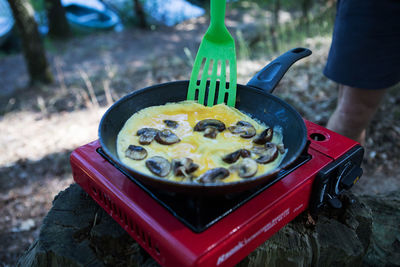 Cropped image of person preparing food in pan on stove