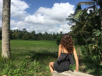 Rear view of woman on field against sky