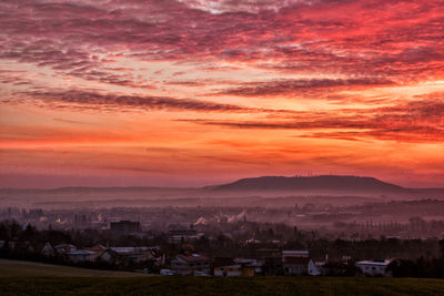 Scenic view of houses against sky during sunset