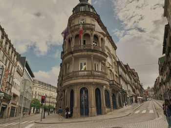 People on street amidst buildings against sky in city