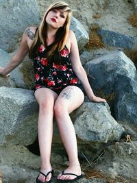 Young woman sitting on rock