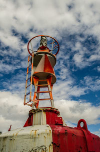 Low angle view of old buoy against sky