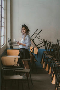 Side view of woman sitting on chair at home