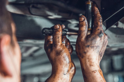 Cropped image of mechanic repairing vehicle