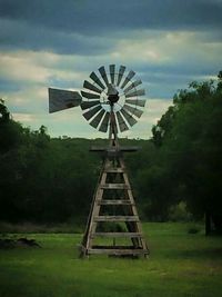 Windmill on field against clear sky