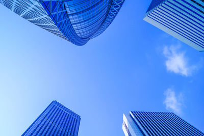 Low angle view of modern buildings against blue sky