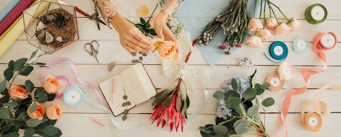 Low section of woman with flowers on table