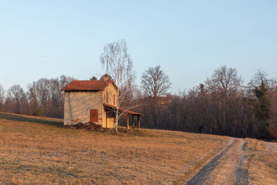 House on field against clear sky