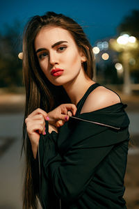 Portrait of beautiful young woman at night