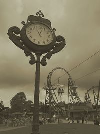 Low angle view of clock against sky