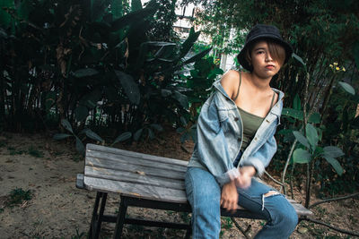 Portrait of young woman sitting on bench