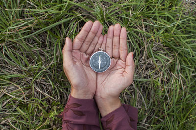 High angle view of human hand holding clock