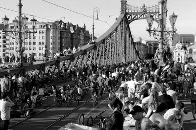 Crowd on bridge in city against sky