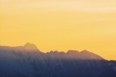 Scenic view of mountains against clear sky during sunset