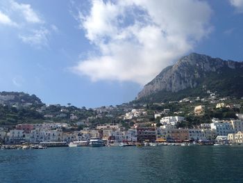 Scenic view of sea by townscape against sky