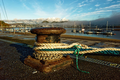 Boats moored at harbor against sky