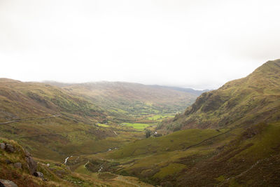 Scenic view of valley and mountains against sky