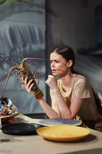 Portrait of young woman having food at table