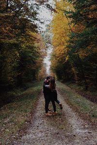 Couple kissing on pathway in forest